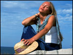 daily Devotion woman wearing jeans by the seashore sunning herself