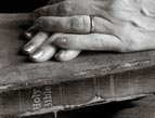 elderly woman's hands resting on worn Bible