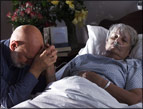 daily Devotion picture of man knealing in prayer beside hospital bed with elderly woman in it.
