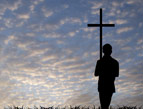 young man silhouette with cross of Christ