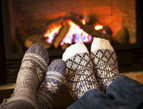 socks on feet propped up near fireplace