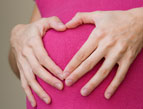 pregnant woman with hands in heart shape