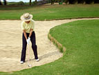 woman playing golf sand trap