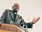 Devotion - black man preacher priest bishop clergy preaching at pulpit with microphone