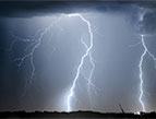 lightning bolts striking the ground at night